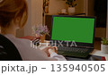 Woman on video call with green screen in home office setting 135940505