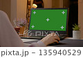 Woman working from home using laptop with green screen 135940529