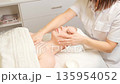 Woman receiving a professional chest and facial massage in a spa wellness center. 135954052