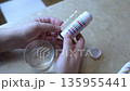 A man in the kitchen tests tap water quality with a test strip. Home testing for drinking water safety, pH, chlorine, and chemical contaminants. 135955441