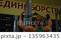 Back view of muscular adult man doing pull-down exercises in gym. Strong sportsman training back muscles on fitness machine. Concept of healthy lifestyle and physical activity. 135963435