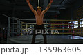 Young adult athletic man warming up before boxing training session in gym. He is preparing for intense workout, fitness concept. Shirtless man with tattoo on his arm in boxing ring. 135963605