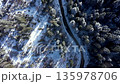 Aerial view of winter road in snow covered mountain forest 135978706