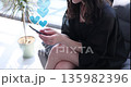 Young woman texting on smartphone with floating hearts 135982396