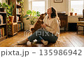 A beautiful woman happily playing with a Shiba Inu in a sunny room A beautiful woman happily playing with a Shiba Inu in a sunny room 135986942