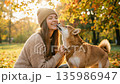 A young woman laughs out loud after her pet Shiba Inu dog licks her face in an autumn park A young woman laughs out loud after her pet Shiba Inu dog licks her face in an autumn park 135986947