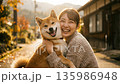 Young woman laughing and hugging her Shiba Inu dog on a Japanese country road in autumn Young woman laughing and hugging her Shiba Inu dog on a Japanese country road in autumn 135986948