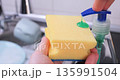 Applying Dishwashing Detergent on Sponge Close-Up 135991504