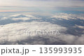 Flying above the clouds airplane window view 135993935