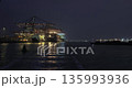 Loading containers on a cargo ships at night 135993936