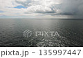 Open sea with dark rippling water and distant horizon under dramatic cloudy sky 135997447