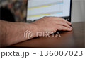 Man Using Laptop Typing and Scrolling Through Data with Blurred Screen 136007023