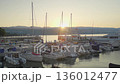 Multiple boats at harbor, silhouetted against sunset sky 136012477