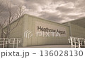 London Heathrow Airport exterior with airplane overhead in winter snowfall, London, United Kingdom 136028130