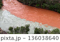 Two rivers merge, one muddy orange and one clear, flowing side by side without mixing. Natural phenomenon where distinct water bodies meet. 136038640