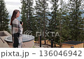 Happy woman with coffee cup on mountain balcony, lady enjoys morning view 136046942
