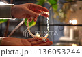 Woman's hands examining a beautiful handmade pearl necklace with heart pendant 136053244