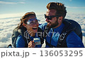 A man and a woman are skydiving in the sky with a cell phone 136053295