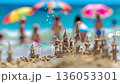 A group of people on a beach with umbrellas and sand castles 136053301