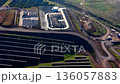 High angle view of an electrical power substation with transformers and high-voltage power lines located next to a large solar array field. 136057883
