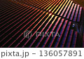High angle perspective of long rows of solar panels with intense sunset reflections and deep shadows between the rows. Abstract aerial view of solar panels at sunset. 136057891