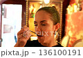Woman savoring food with eyes closed in elegant restaurant 136100191