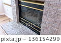 Tall vertical framing of fireplace corner with clear visibility of brick stacking and structure. Natural daylight illuminates the scene. 136154299