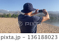 man making picture panorama lake beach mountains amateur mobile phone 136188023