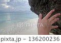female hand touching rock on Beach calm relax holidays concept enjoy life style pov 136200236