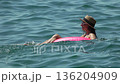 Woman Floating Sea: Woman in hat, sunglasses on pink ring, relaxing in the sea, enjoying summer vacation. 136204909