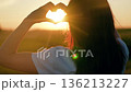 Girl made heart out palms. Symbol love in hands teenage girl, sun. Healthy heart. Happy girl makes heart with fingers in nature. Young woman loves travel. Travel, relax in nature. Happy life teenager 136213227