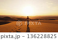 Solitary Woman Walking Across Sand Dunes in Peru at Sunset 136228825