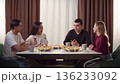 Group happy young adult friends having lunch together. People communicating talk enjoy pizza drink tea at home. Cozy conversation during relaxed gathering. Casual students team meeting. Cool youth. 136233092