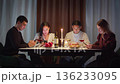 Group friends with cell mobile phone addiction having evening wine dinner together. People celebrating event. Awkward ignore double date problem at restaurant or home. Holiday candle light atmosphere. 136233095
