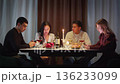 Group friends with cell mobile phone addiction having evening wine dinner together. People celebrating event. Awkward ignore double date problem at restaurant or home. Holiday candle light atmosphere. 136233099