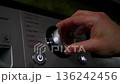 Smart home appliances. Adjusting washing machine setting. Hand turning the dial of a modern washing machine. Daily chores, copy space 136242456