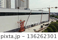 Construction workers on a scissor lift at a building site 136262301