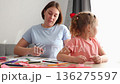Mother and Caucasian little daughter decorate valentines together. The concept of Mother's Day and preschool education. 136275597