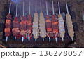 Juicy meat shish kebab and lula kebab on skewers cooking on a charcoal grill with smoke, top view 136278057