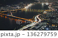 Aerial perspective captures a bustling city at night with bright lights reflecting on the river, highlighting bridges and moving vehicles. Time-lapse, Seoul, South Korea 136279759