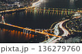 Aerial perspective captures illuminated bridges and busy traffic flowing along roads at night with reflections on the water surface. Time-lapse, Seoul, South Korea 136279760