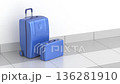Blue plastic suitcase and briefcase on tiled floor 136281910