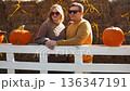 Couple sitting together with pumpkins at autumn farm 136347191