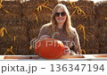 Pregnant woman holding pumpkin on farm outdoors 136347194