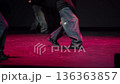 Synchronized movement of dancers' legs in wide trousers on stage 136363857
