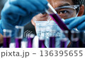 Scientist conducts experiments with test tubes and liquids in laboratory at a science facility 136395655