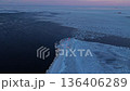 Approaching vessel at sunrise among ice floes. Ship navigates icy waters towards dock at dawn with shadows 136406289