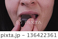 Adult Woman Eating a Chocolate Candy Indulgence Unhealthy Treat Concept 136422361