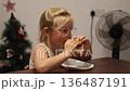 Little triplet sisters eating a burger in the kitchen 136487191