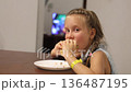 Little triplet sisters eating a burger in the kitchen 136487195